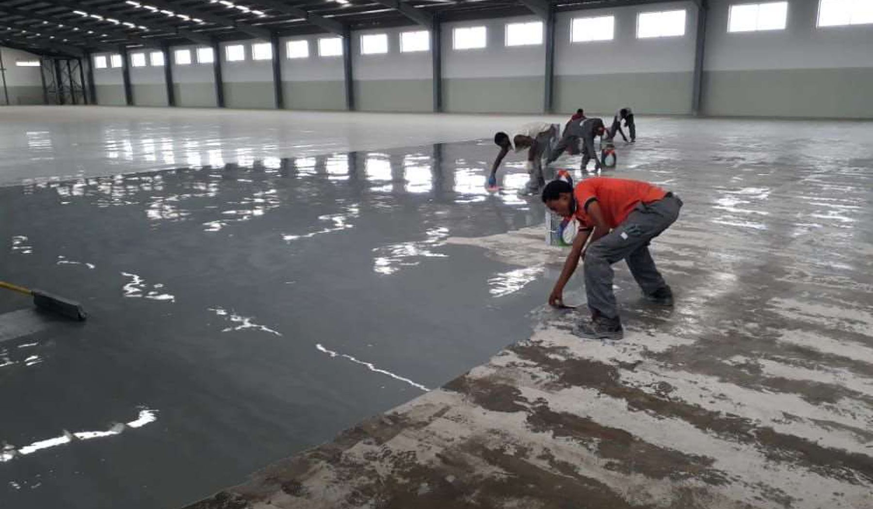 SD Aqua Proof crew applying floor coating in an industrial warehouse